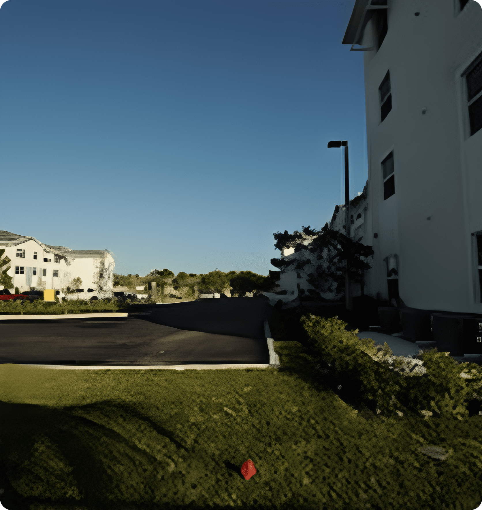 Residential buildings with trees and a clear sky in the background.