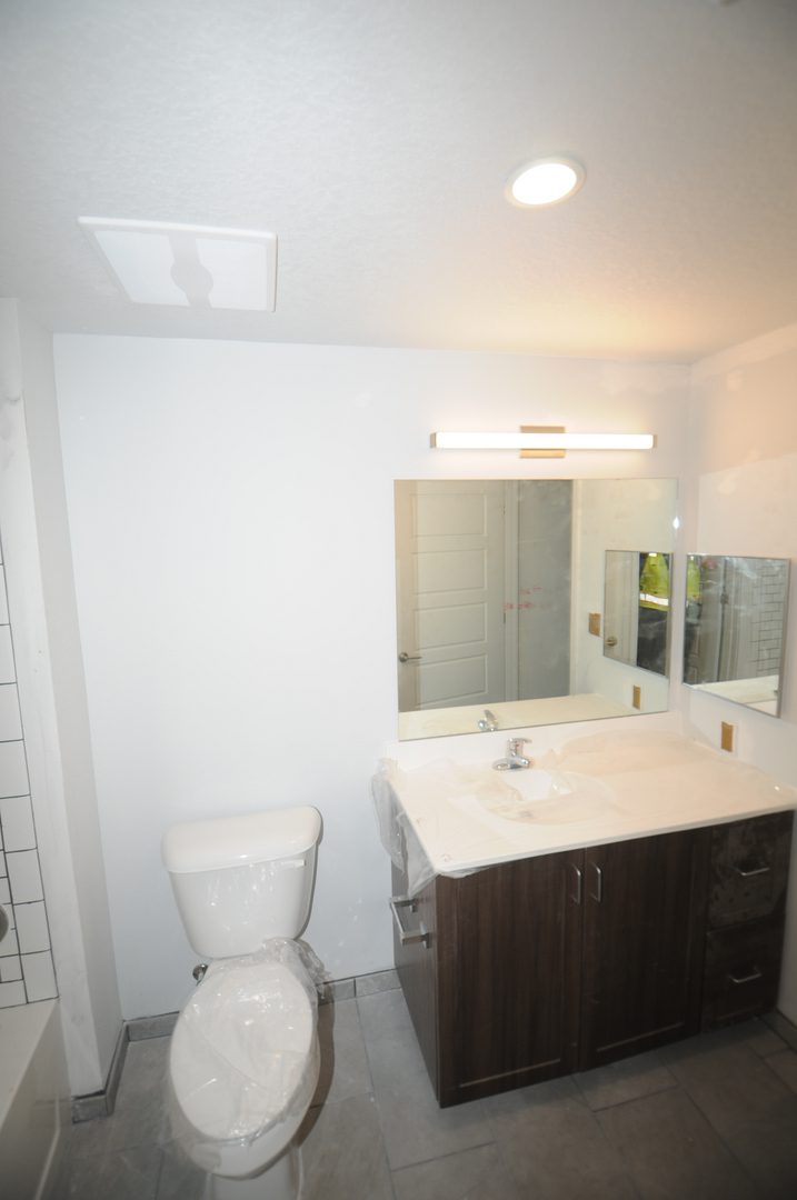 Minimalist bathroom with tiled shower wall
