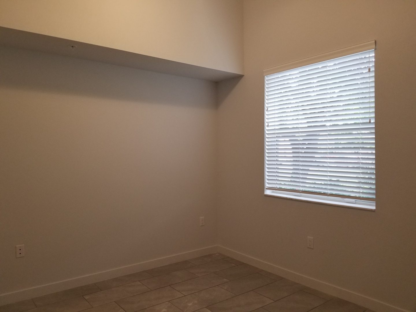 Minimalist room with blinds and neutral walls