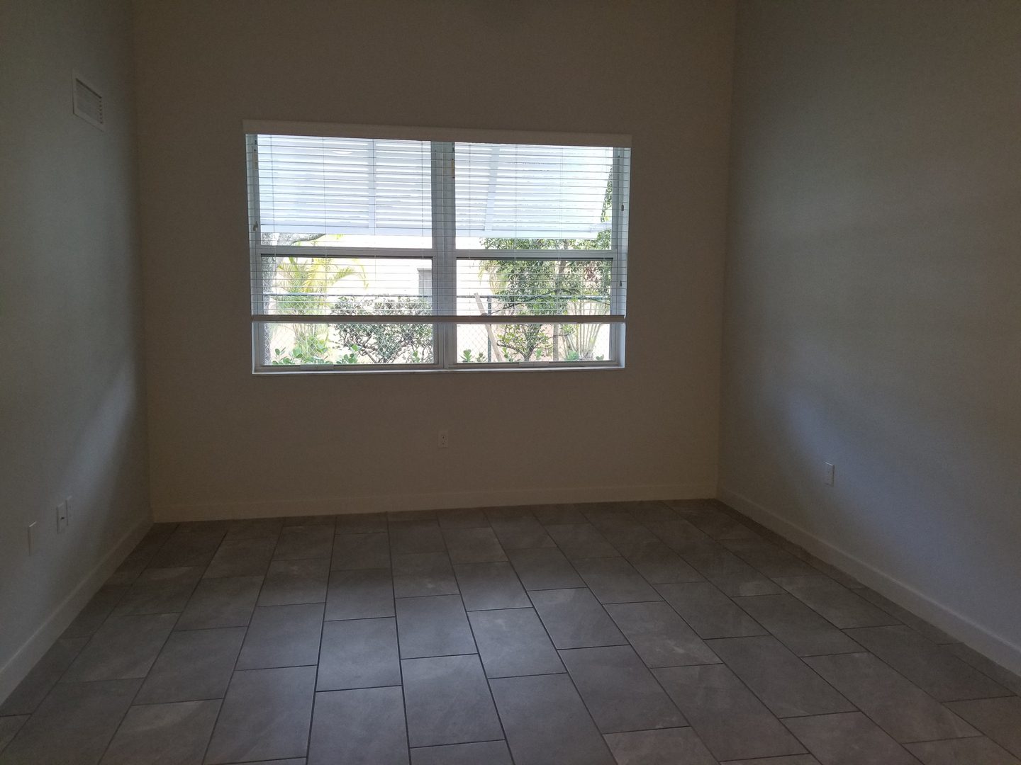 Empty room with tiled floor and window.